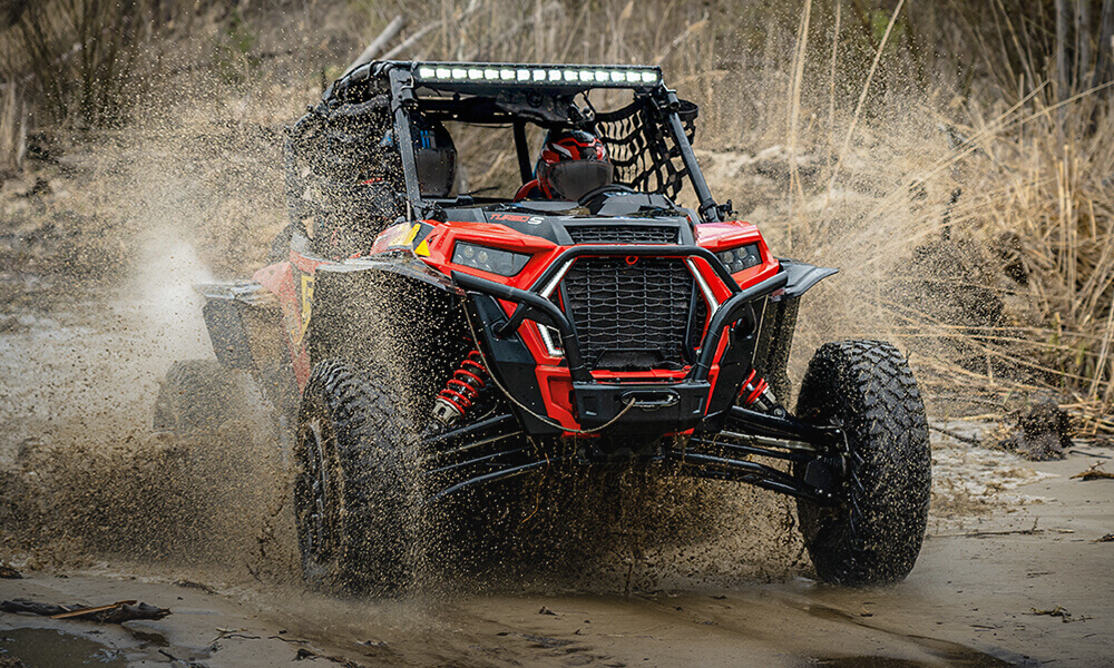 UTV driving a trail through a puddle